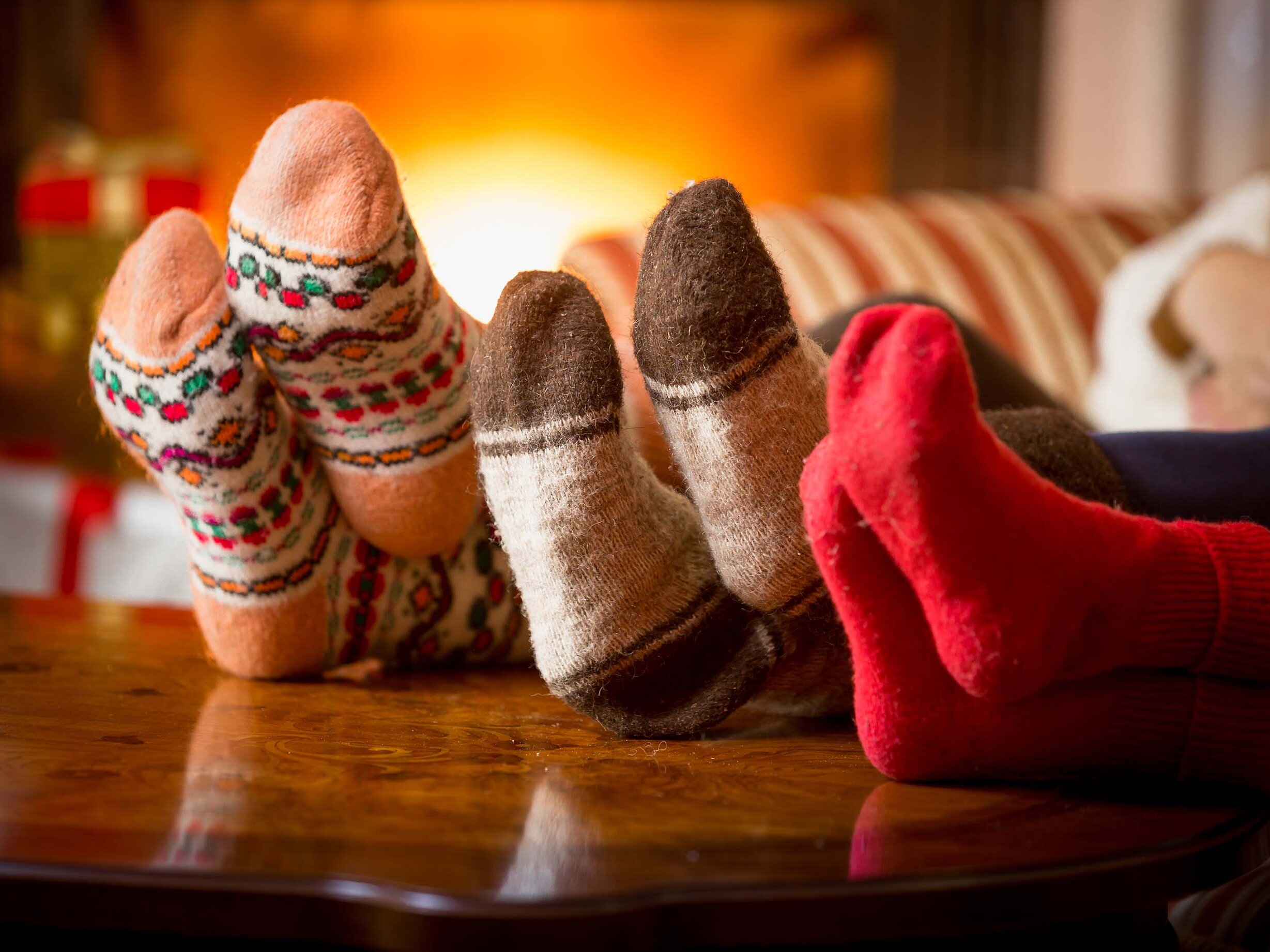 ESW PK Wärme Ideal Drei Personen mit den Füßen auf dem Tisch und bunten Socken an