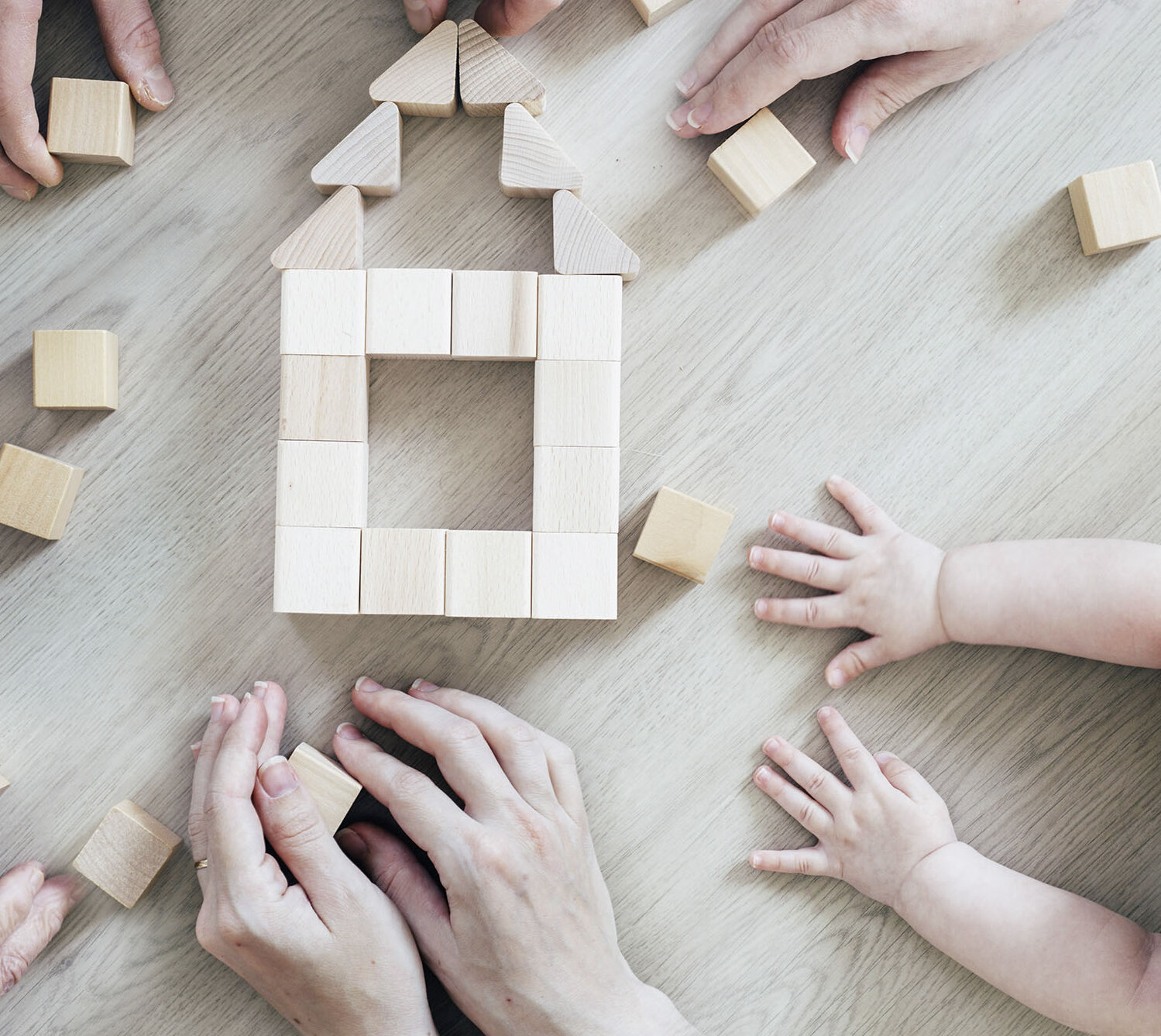 Familie baut ein Haus mit Bauklötzen